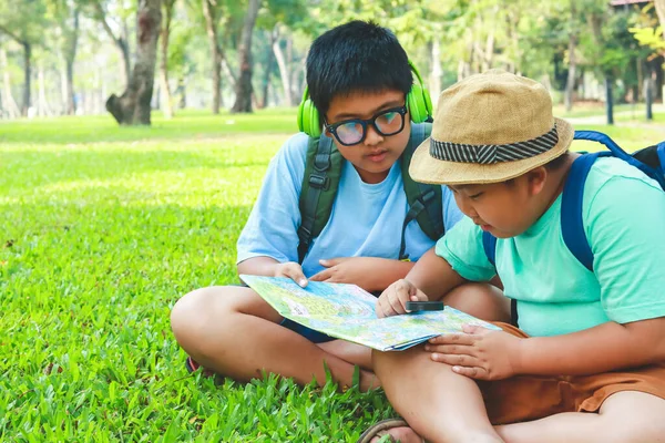 两个男孩在花园里看地图学习 — 图库照片
