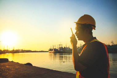 Erkek mühendis gerekli şartları yerine getirmek için telsizi elinde tutuyor..