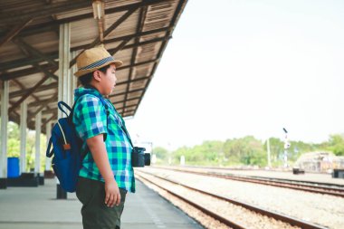 Asyalı bir çocuk elinde kamera Trenle seyahat ediyor