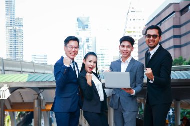 İş adamları, erkekler ve kadınlar Defteri tutun, kollarınızı kaldırın, mutlu olun, başarıyla çalışın