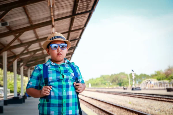 小男孩提着包 等待车站的火车开过去 — 图库照片