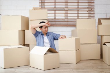 Asyalı adamlar online iş yapıyorlar. Bütün gün eşyaları büyük karton kutulara doldurmaktan yoruldular. Teslimat kavramı. Boşluğu kopyala