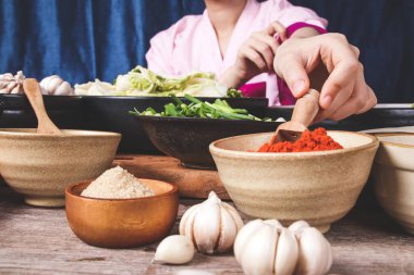 Acı biber tozu kepçelemek için tahta kaşık tutan kadın eli kimchi pişirmek için bir malzemedir. Kore mayalanmış yemek kavramı..
