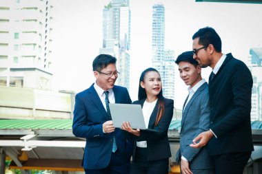 4 ofis çalışanı, alt toplantı, olay yerinde. Bir defter bilgisayarı tut.