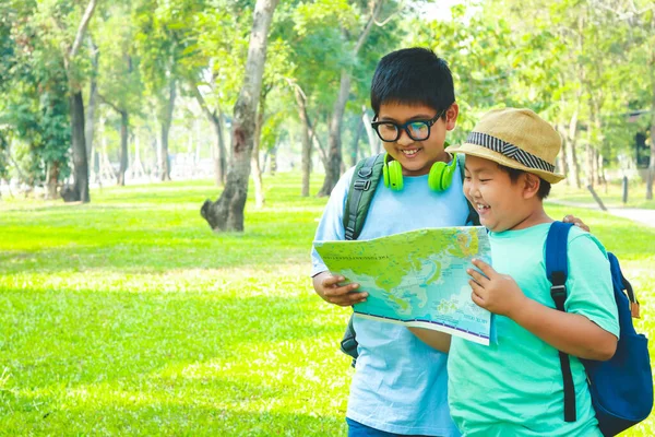 两个男孩进行实地考察 拿着世界地图去学习 — 图库照片