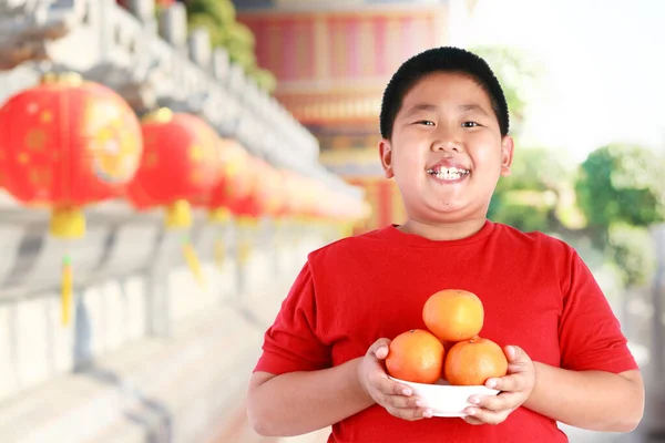Ragazzo Asiatico Con Una Camicia Rossa Tiene Frutto Arancione Bambini — Foto Stock