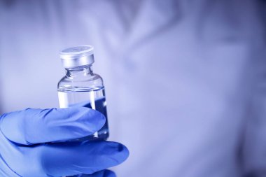 Doktor ya da bilim adamı bir şişe COVID-19 aşısını hastanede enjekte etmeye çalışır. Tıbbi deneyler koronavirüsün yayılmasını engelliyor. Boşluğu kopyala