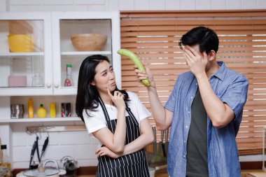 Asyalı çiftler evdeki mutfakta birlikte yemek pişirirler. Onlar oyun oynamaktan ve birbirleriyle alay etmekten zevk aldılar. Patlıcan tutan adam. Aile kavramı, çift hayatı kurmak Aile kurmak