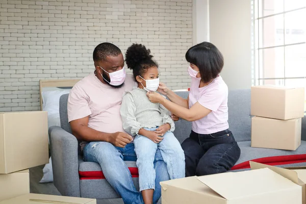African american family Parents and daughters move into their new homes, wearing masks to prevent dust and viruses.