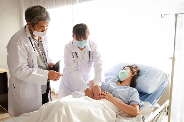 Δύο Ασιάτες Γιατροί Εξέτασαν Τον Κοιλιακό Πόνο Μιας Γυναίκας Ξαπλωμένης — Φωτογραφία Αρχείου