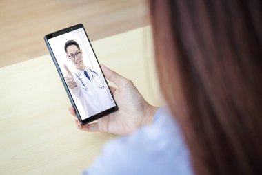 Siyah akıllı telefon kavramı internet teknolojisi ile iletişime bağlanır. Doktor hastayı görüntülü arama ile muayene edebilir..