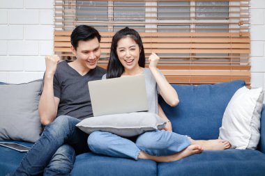 Evde çalışan Asyalı çift, koronavirüsün yayılması sırasında sosyal mesafeyi koruyorlar. Evden çalışma kavramı. Mutlu çift