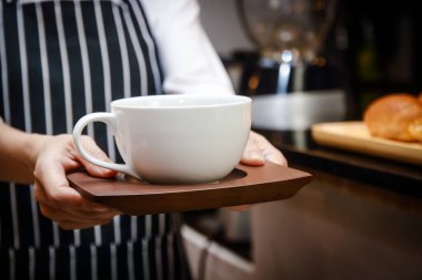 Müşterilere göndermek için elinde beyaz kahve fincanı tutan bir adam tarafından yapılmış. Kahve dükkanı konseptleri, girişimciler, koronavirüs salgını sırasında iş yapmak.