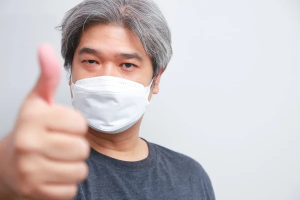 Fet Asiatisk Man Med Grått Hår Bär Vit Mask Tummen — Stockfoto