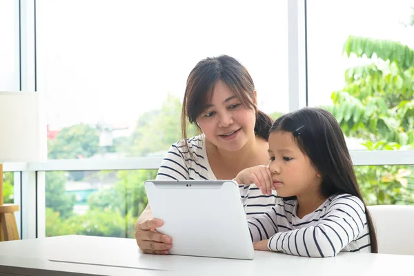 可爱的亚洲小女孩和一位老师在平板电脑上在线学习 有一个母亲帮忙教书 验尸官爆发期间的教育概念 社会疏离 — 图库照片