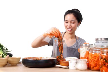 Güzel Asyalı kadın otur ve kimchi yap, Kore mayalanmış yemeği. Gıda temizliğini korumak için koruyucu eldiven takıyor. Beyaz arka plan. Kore mayalanmış gıda konsepti sebzelerden yapılır.
