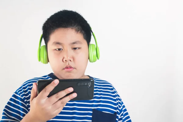 亚洲胖男孩头戴耳机 手持智能手机 通过视频电话与老师在线学习 远程教育 概念在考拉病毒大流行时期使用现代技术 — 图库照片