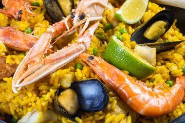 Ahşap bir masada paella dolu bir tava.