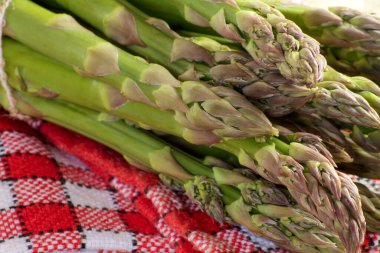 Ahşap bir masada çiğ yeşil kuşkonmaz