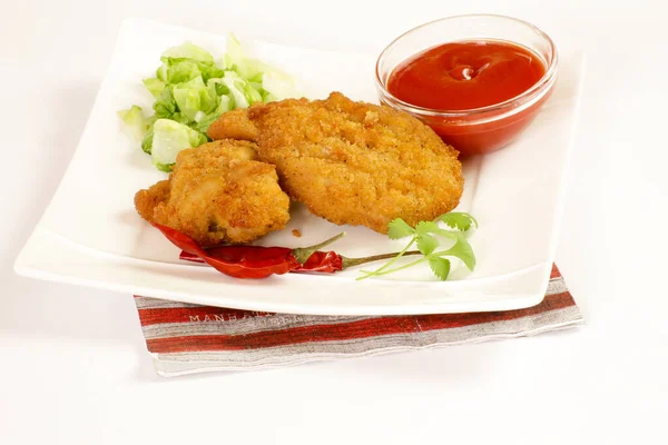 breaded chicken pieces with ketchup sauce on a plate