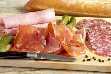 Kesme tahtasında çeşitli et parçaları var.