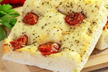 Kesme tahtasındaki kiraz domatesli fougasse.