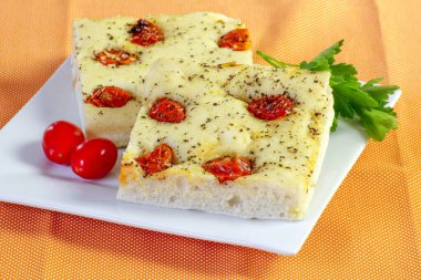 Kesme tahtasındaki kiraz domatesli fougasse.