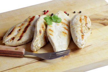 Kesme tahtasında ızgara tavuk filetosu.