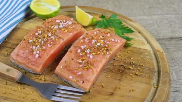 Pieces of raw salmon with spices on a cutting board — Stock Footage Pieces Raw Salmon Spices Cutting Board Video Clip