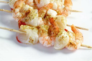 Karides şişleri ve baharatlı deniz tarakları.