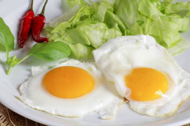 Bir tabak kızarmış yumurta ve yeşil salata.