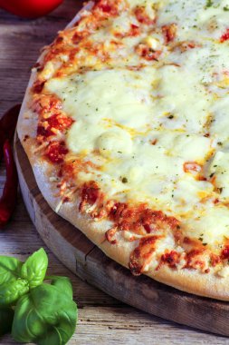 Tahta bir masada peynirli pizza.