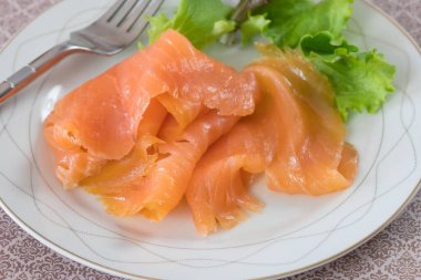 Beyaz tabakta taze marullu somon filetosu.