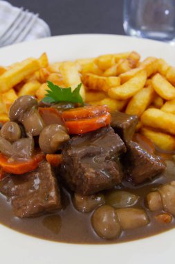 fried potatoes with stewed beef, mushrooms and carrot 