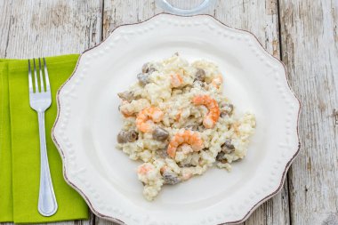 Beyaz tabakta karides ve mantarlı risotto..