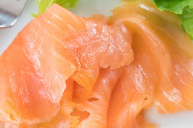 Beyaz tabakta taze marullu somon filetosu.