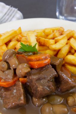 fried potatoes with stewed beef, mushrooms and carrot 