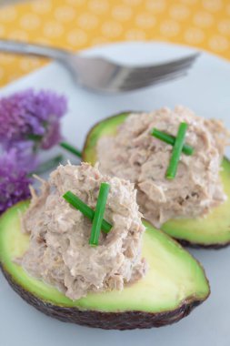 Ton balığı salatası ve beyaz tabakta soğan ile doldurulmuş avokadolar..