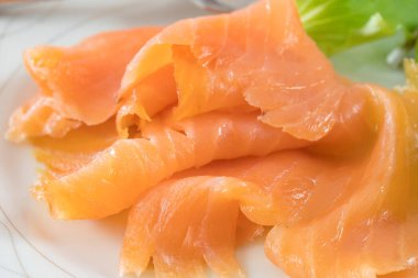 Beyaz tabakta taze marullu somon filetosu.