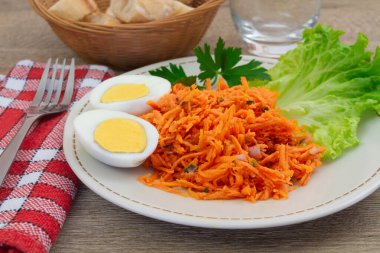 Marul, maydanoz filizi, rendelenmiş havuç ve iki haşlanmış yumurta..