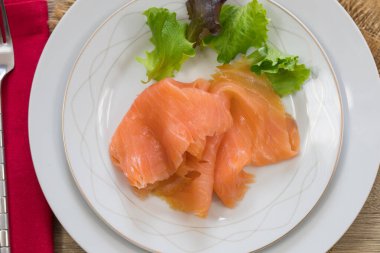 Beyaz tabakta taze marullu somon filetosu.