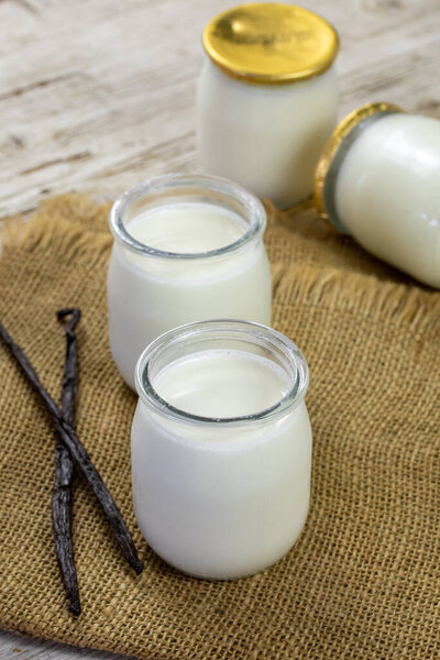 Йогурт в стеклянных банках на салфетке.