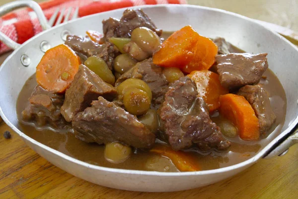 a cuisine photo of beef, mushrooms and carrot stewed in a dish