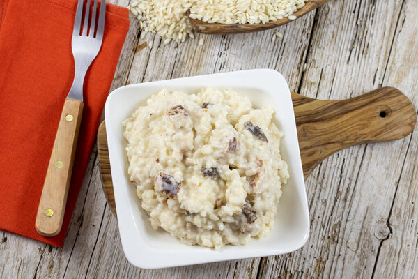 Risotto with chicken and morels in a white bowl.