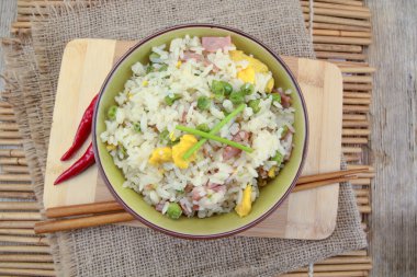 Tahta kesme tahtasının üzerinde bir kase Çin pirinci.