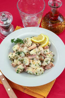 Tabakta sarımsak ve maydanozla pişirilmiş ahtapot parçaları..