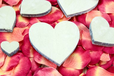 Gül yapraklarının arka planında kalpler.