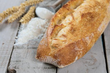 Tahta bir masada un ile taze pişmiş ekmek