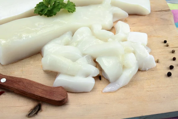 Tahta kesme tahtasındaki çiğ mürekkep balığı..