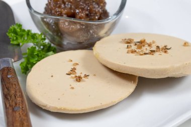 Kaz ciğeri dilimleri ve beyaz bir tabakta ziyafet..